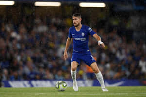 足球員在夜間比賽中雨中運球。