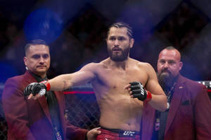 MMA 選手在八角籠中與官員一起慶祝勝利。