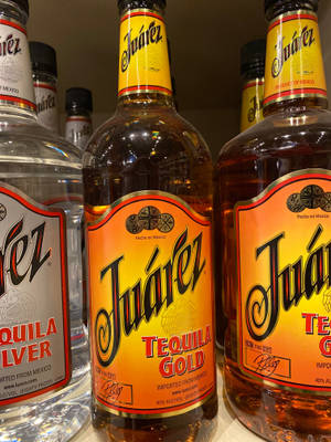 Juárez 龍舌蘭酒瓶以透明和金色品種陳列在商店貨架上。