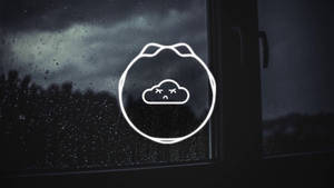 一個悲傷的卡通雲貼紙在夜間的雨窗上發光。