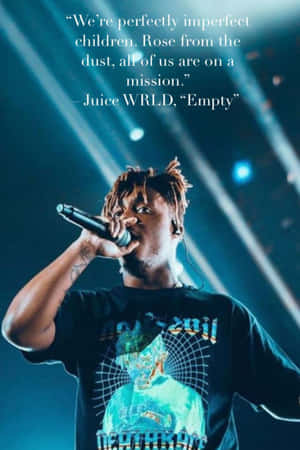 Juice WRLD 在藍色燈光和引言覆蓋層中於舞台上對著麥克風唱歌。 — 塗鴉 壁紙