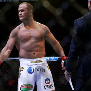 肌肉發達的MMA拳手穿著白色短褲站在八角籠內。