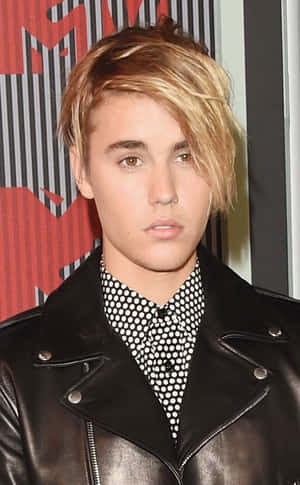 Justin Bieber 在 MTV 活動中穿著黑色皮褸和波點恤衫。