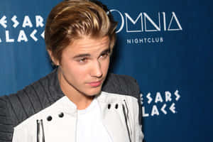 Justin Bieber 在夜店活動中穿著白色和灰色外套。
