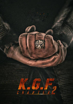 一隻握緊的拳頭戴著獅子戒指，被另一隻手握住，電影《KGF 第2章》海報。