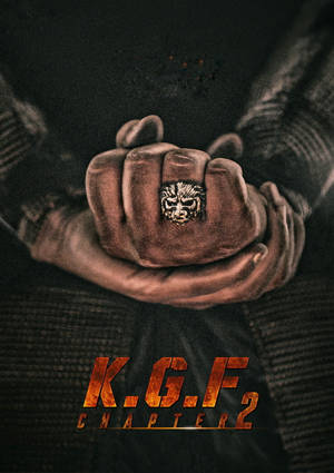 戴著獅子戒指的緊握拳頭和火焰般的KGF Chapter 2標題文字。