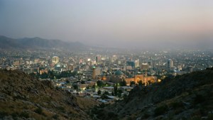 城市燈光在黃昏時分在崎嶇的山脈和歷史建築之間閃耀。