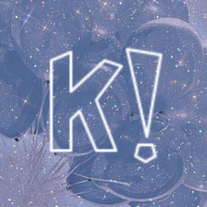 一個發光白色的「K!」被藍色氣球和閃爍星星包圍。
