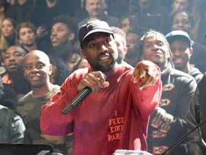 Kanye West 在舞台上表演，身後有群眾