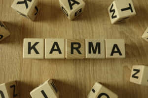 木製積木在木桌上拼出 karma，散落著字母方塊。