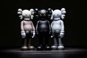 三隻米色、黑色和白色的KAWS Companion公仔排成一排。