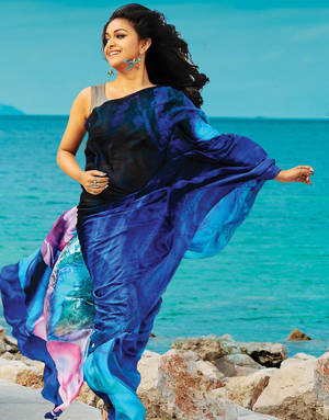 身穿彩色紗麗的女子在岩石海岸邊跳舞