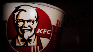 昏暗燈光下帶有山德士上校標誌的 KFC 桶。 — 機關槍凱利 壁紙