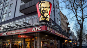 黃昏時城市街道上帶有大型山德士上校招牌的KFC餐廳。