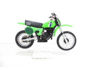 鮮綠色Kawasaki KX80越野電單車喺白色展示支架上。