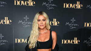 Khloé Kardashian 在品牌活動中穿著黑色短上衣微笑。 — 金·卡戴珊 壁紙
