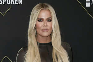 Khloé Kardashian 在一個華麗的活動中穿著黑色服裝搭配金色點綴。 — 金·卡戴珊 壁紙