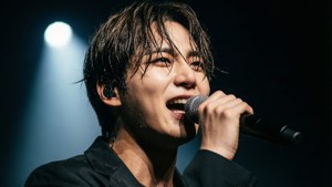 男歌手在聚光燈下拿著麥克風在舞台上表演
