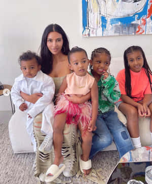 Kim Kardashian 和她的四個孩子一起坐在現代客廳的沙發上。