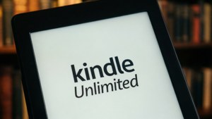 Kindle Unlimited 標誌顯示在平板電腦上，背景為書架。