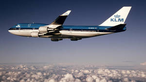 KLM波音747在晴朗藍天的雲層上方飛行