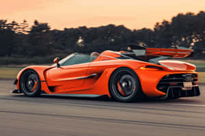 橙色Koenigsegg Jesko在日落時分的道路上飛馳
