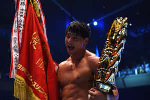 摔角手在比賽獲勝後手持獎盃和旗幟。