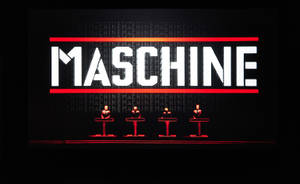 四位音樂家在舞台上，紅色燈光的「MASCHINE」標誌下。 — 音樂 GIF 壁紙