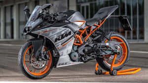 一輛KTM RC 390運動電單車停在橙色支架上，位於瀝青路面。 — 機車 壁紙