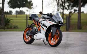 一架白色和橙色嘅KTM RC電單車停泊喺碎石路上。 — 機車 壁紙