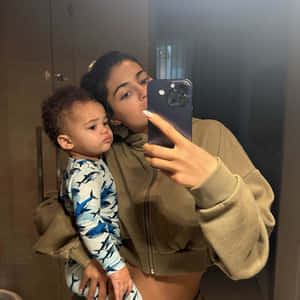 母親抱著穿著鯊魚睡衣的幼兒，在浴室對著鏡子自拍。