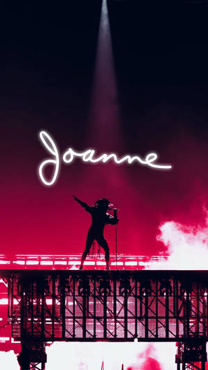 歌手在燈光舞台上表演，'Joanne' 以發光字母呈現。 — Beyoncé 壁紙