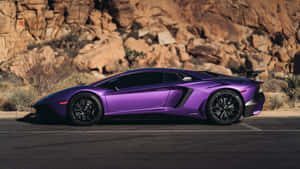 紫色林寶堅尼 Aventador SVJ 停泊喺瀝青路上，靠近岩石地形