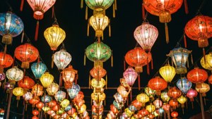 密集的發光紙燈籠，顏色各異，懸掛在黑暗的天空中。