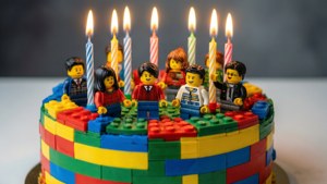 一個LEGO蛋糕，上面有點燃的蠟燭和人仔，用於生日慶祝。