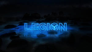 夜間在黑暗岩石和水面上發光的霓虹藍色LEGION標誌。