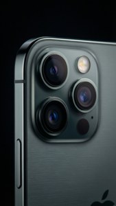深色背景上帶有三鏡頭系統和 Apple 標誌的銀色 iPhone