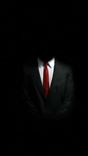 一個身穿西裝和紅色領帶、在黑暗中看不見臉孔的人。 — 安卓 壁紙