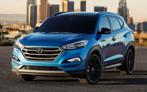 藍色現代 Tucson SUV 停在城市中，背景是日落時分的天際線。 — 1280x800 壁紙