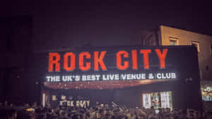 Rock City 現場音樂場地外的夜間人群，帶有發光的紅色標誌。