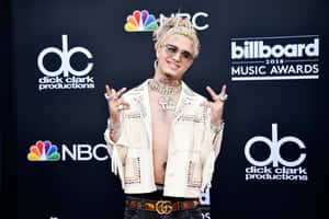 身穿鑲有寶石白色外套的男子在Billboard音樂獎上擺姿勢。