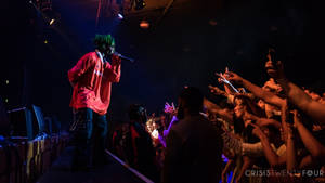 音樂家在舞台上表演，人群伸手捕捉這一刻。