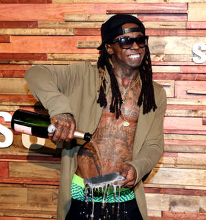 男人在活動中將香檳倒在托盤上，背景為木牆。 — Lil Wayne 壁紙