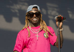 饒舌歌手 Lil Wayne 在舞台上拿著麥克風微笑。 — Lil Wayne 壁紙
