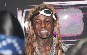 留著辮子頭和護目鏡的男人在音樂會上微笑。 — Lil Wayne 壁紙