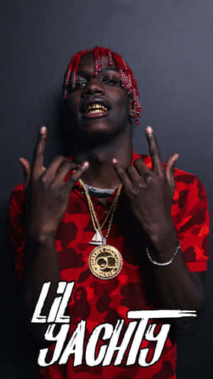 Lil Yachty 身穿紅色迷彩襯衫和金色鏈條，做出手勢。 — 9:16 壁紙