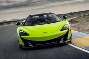 青檸綠色McLaren 570S開篷跑車在賽道上比賽，駕駛員戴著頭盔。 — MacBook Pro M3 壁紙