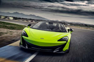 青檸綠色McLaren 570S開篷跑車在賽道上以模糊動態飛馳。 — Surface Pro 壁紙