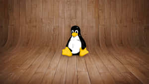 毛絨Linux企鵝吉祥物坐在木地板上，背景是木牆。