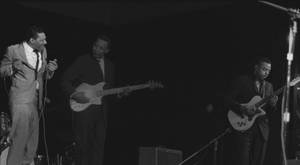 三位音樂家在舞台上以黑白現場表演 — 復古gif 壁紙
